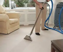 Carpet cleaning professional removing dirt and stains with a hot-water extraction tool in a home, Cleveland, OH.