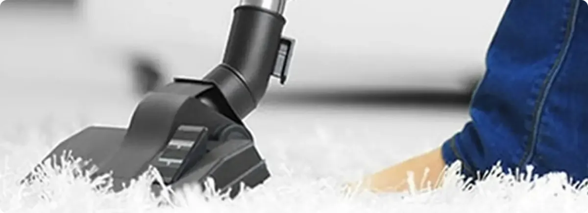Close-up of a professional vacuuming a white carpet in Beachwood.